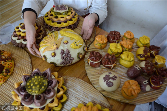 Artisan makes flower cakes for Chinese New Year