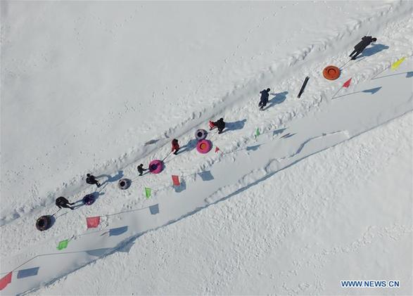 Tourists play with snow at ski resort in E China's Shandong
