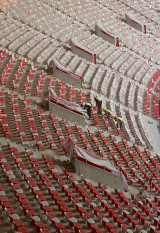 Workers clean the seats inside China's National Stadium, also known as the 'Bird's Nest', Feb. 17, 2008. Constructions of the 91,000-seat arenas, the venue to hold the opening and closing ceremonies for the coming Olympics, near completion as the 80,000 unmovable seats have been installed by the end of January. [Xinhua]