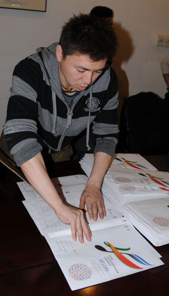A staff member sorts out envelopes filled with entries for the Beijing Olympics theme song in Beijing, March 10, 2008. Monday was the deadline for entries.