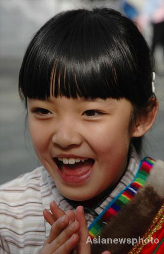 Yang Ke, a girl from the Tibetan ethnic group, smiles as she plays with other pupils at Lanzhou Qing Hua Primary School, in Lanzhou, capital of Northwest China's Gansu Province, March 15, 2008. The Beijing Organizing Committee for the Olympic Games (BOCOG) recently invited the school, which is known for having students from many ethnic groups, to submit photographs of smiling children for possible use in the August 8 Opening Ceremony of the Beijing Olympic Games. BOCOG started collecting photographs of children's smiling faces from around the world on Sept 4 last year. [Asianewsphoto] 