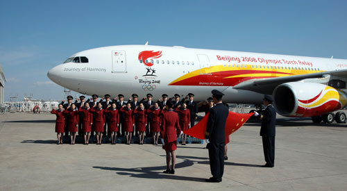 Crew members of the Olympic Torch plane take oath in front of the plane at Beijing Capital International Airport March 27, 2008. The plane, chartered to carry the torch back to Beijing, will take off for Athens on Saturday.
