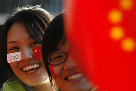 Two overseas Chinese smile before the start of the Beijing Olympic torch relay in Canberra, April 24, 2008. [Agencies]