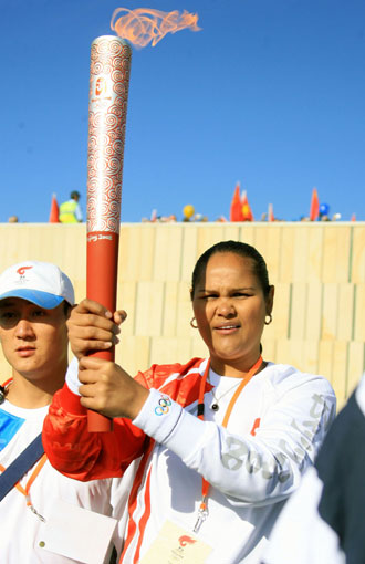 Tania Major (L), the young indigenous leader from Queensland holds the Beijing Olympic torch before running the opening leg of the torch relay in Canberra, Australia, April 24, 2008. Eighty torch runners will run through the 16-km routes which started from the Reconciliation Place in front of the old parliament house and will end at the Stage 88 in the Commonwealth Park. [Xinhua]
