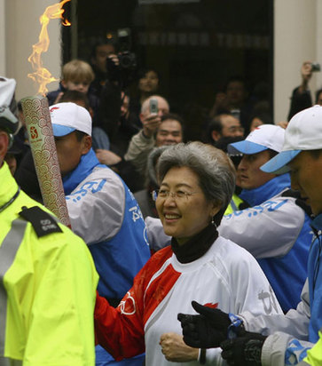 China's ambassador to Britain Fu Ying carries the Olympic torch through China Town in central London April 6, 2008. [Agencies]