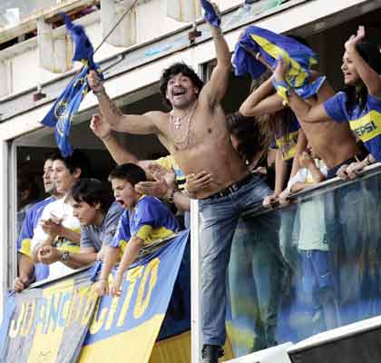 Former Argentine soccer player Diego Maradona (C) celebrates after Boca Juniors tied their Argentine First Division soccer match against River Plate at the La Bombonera stadium in Buenos Aires March 26, 2006. 