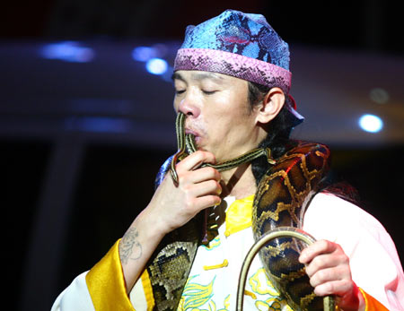 A stuntman swallows a snake with his mouth and then allows it to come out from his nose during a performance in Nanjing, capital of China's Jiangsu province, July 2, 2006. [newsphoto]