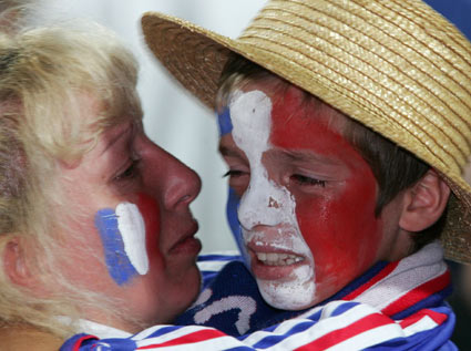 A young fan cries in the arms of his mother at Jean Bouin stadium in Paris after the defeat of France at the World Cup 2006 final soccer match against Italy July 9, 2006. [Reuters]
