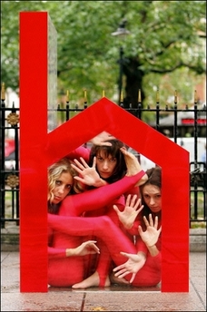 Three contortionists squeeze into a small perspex house in Leicester Square, central London, in a protest organised by the charity 'Shelter' against overcrowded housing conditions for families and children in England.(AFP/John D McHugh) 