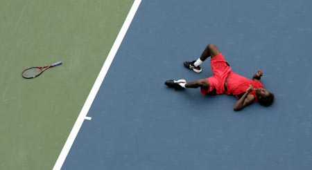 France's Gael Monfils falls while playing a shot to Michael Russell of the United States during their match at the U.S. Open tennis tournament in New York, August 30, 2006. 