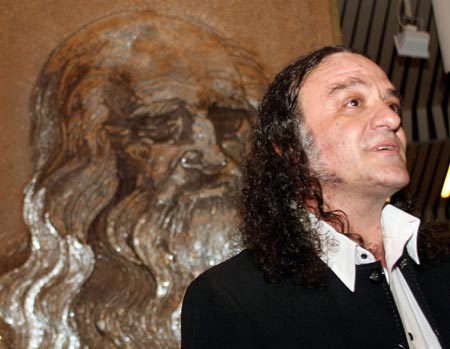 Saimir Strati speaks in front of the portrait of Leonardo Da Vinci, which he created with industrial nails, at the International Centre of Culture in Tirana September 4, 2006. Strati, 40, was recognised by Guinness World Record officials for having created the world's largest nail mosaic, which consisted of about 500,000 industrial nails on a 8 square-meter wooden board. 