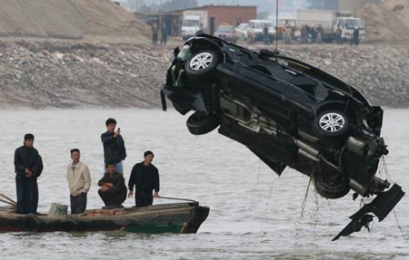 A car is pulled out of water after it crashed into the Jin River from a bridge in Quanzhou, East China's Fujian Province, December 3, 2006. The crash left one man dead. [Xinhua]