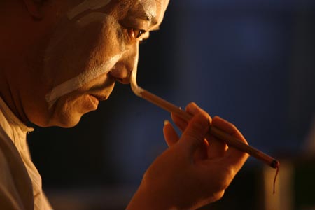 A Chinese artist applies make-up before performing in an English version of the traditional Chinese opera Monkey King at a theatre in Shanghai December 8, 2006. Among the performers is Ghaffar Pourazar of Britain (not in photo), the first foreigner to complete the rigorous training at the Beijing Opera School and the National Academy. He is performing with Chinese artists from the International Centre for Beijing Opera, and other troupes, at their first show in Shanghai.