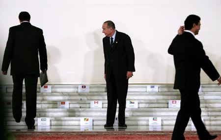 France's President Jacques Chirac (C) waits for fellow leaders to take their places during a family photo at the two-day Francophone Summit, hosted for the first time by an Eastern European country, in Bucharest September 28, 2006.