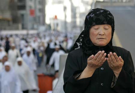 A pilgrim from China prays outside the Grand Mosque in Mecca after performing the noon prayer December 25, 2006.