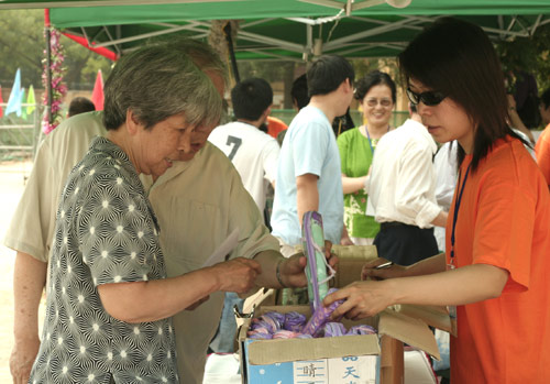 Voters choose the umbrella as a souvenir after voting on demolishment and reconstruction of old buildings in Juixiaqiao Sub-district in Beijing, June 9, 2007. Local government and the real estate developer jointly organize the vote on Saturday to see if majority residents of over 5000 families accept the new compensation policy after failed attempts to reach an agreement through other ways. Both notary officials and supervisors are invited to monitor the vote that runs from 9 a.m. to 9 p.m. at six ballot booths. [Sun Yuqing/www.chinadaily.com.cn]