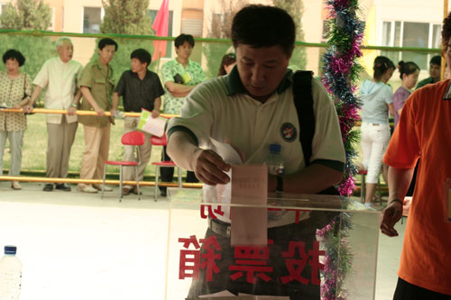 A voter casts his vote on demolishment and reconstruction of old buildings in Juixiaqiao Sub-district in Beijing, June 9, 2007. Local government and the real estate developer jointly organize the vote on Saturday to see if majority residents of over 5000 families accept the new compensation policy after failed attempts to reach an agreement through other ways. Both notary officials and supervisors are invited to monitor the vote that runs from 9 a.m. to 9 p.m. at six ballot booths. [Sun Yuqing/www.chinadaily.com.cn]