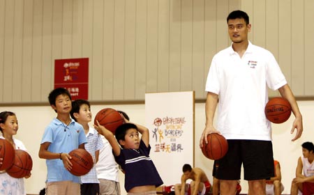 Chinese NBA star Yao Ming plays basketball with AIDS orphans during an event to promote care for the AIDS orphans in Shanghai, July 8, 2007. Yao Ming and other NBA stars played and exchanged gifts with tens of AIDS orphans from Anhui Province, Yunnan Province and other regions. [Xinhua]