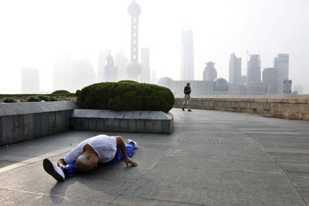 A man does his morning exercise at the Bund on the banks of the Huangpu River in Shanghai August 6, 2007. The Bund is one of the most famous tourist sites in Shanghai. Locals use the Bund as a place for morning exercises as well as other activities.