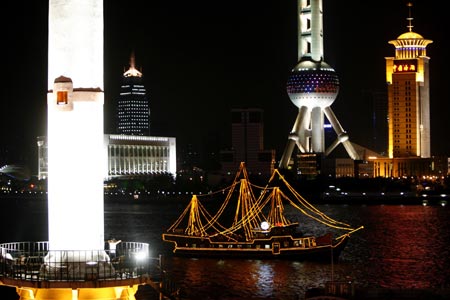 A tourist boat sails across the Huangpu River opposite the Bund in Shanghai August 6, 2007. The Bund is one of the most famous tourist sites in Shanghai. Locals use the Bund as a place for morning exercises as well as other activities.