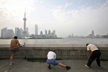 People do their morning exercise at the Bund on the banks of the Huangpu River in Shanghai August 6, 2007. The Bund is one of the most famous tourist sites in Shanghai. Locals use the Bund as a place for morning exercises as well as other activities.
