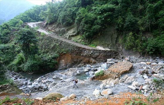 Villagers rebuild sole road after flood