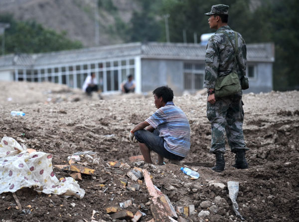 Landslide survivors waiting for families on ruins