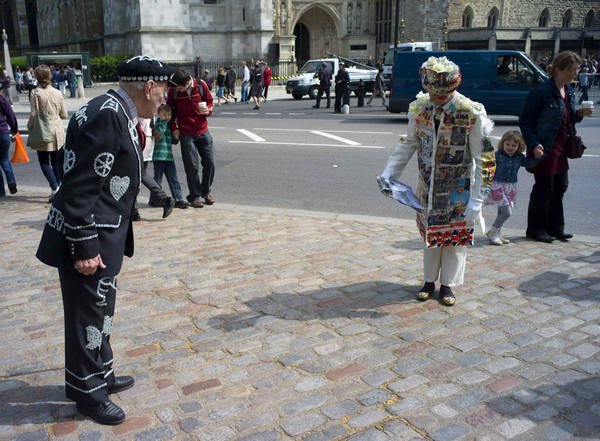 William Willis wears a coat covered in photographs of Britain's Royal family as he greets the Pearly King of Wandsworth (L) on the pavement outside Westminster Abbey, in London April 26, 2011. Coat covered in pics of Britain's Royal family