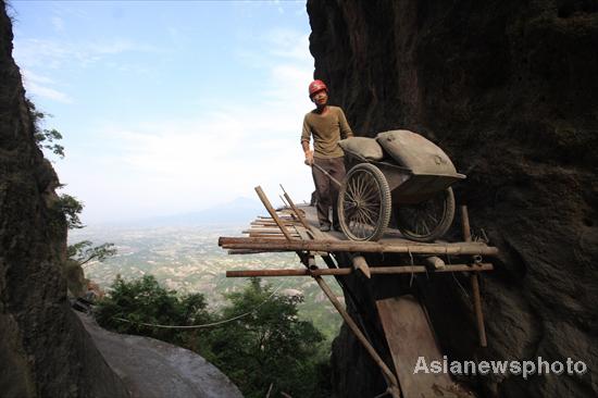 Chinese spider men work on cliffs