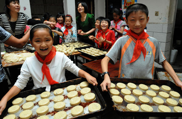 Children learn to make festival delicacy