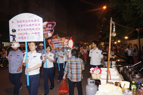 Officers hold slogan placards for urban management