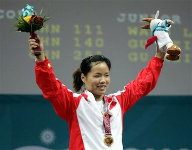 Chen Yanqing waves on the podium during an awarding ceremony for the Asian Ganes weightlifting women's 58 kg in Doha, Qatar, Sunday, Dec. 3, 2006. She won the gold medal by setting a new world record. (AP 