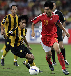 Zheng Zhi (R) and Malaysia's Shahrulnizam Mustapa fight for the ball during their 2007 AFC Asian Cup Group C soccer match in Kuala Lumpur July 10, 2007. 
