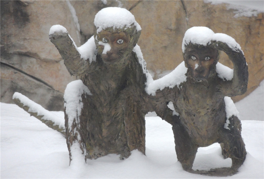 Stone monkeys enjoy snowfall