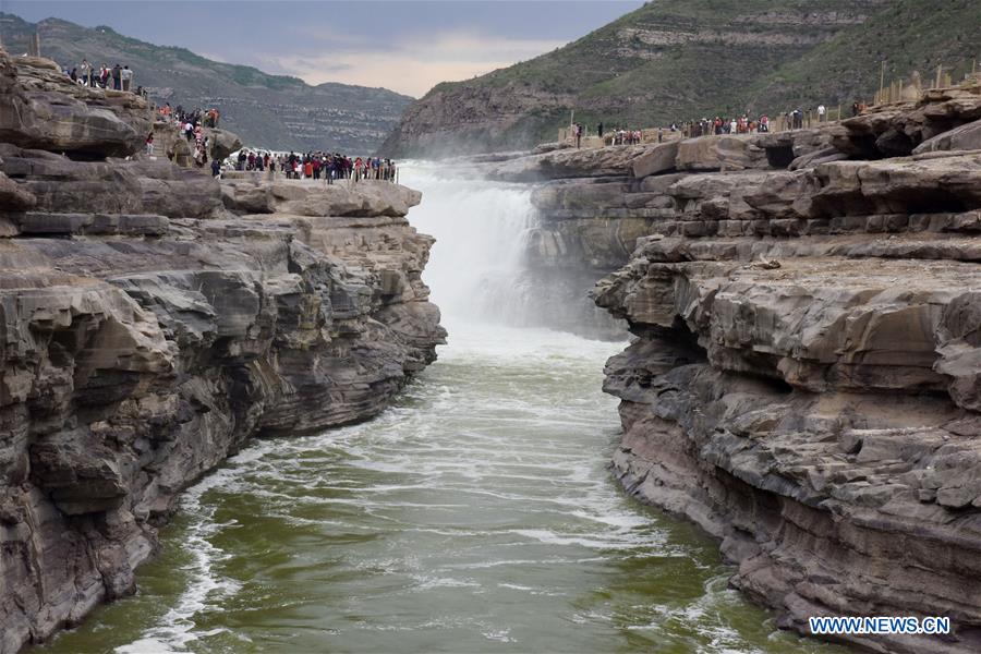 Visitors view Hukou Waterfall in N China