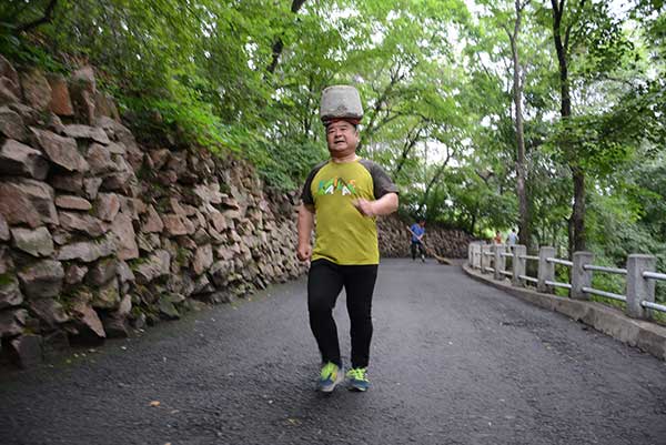 Man exercises with 40kg stone on his head