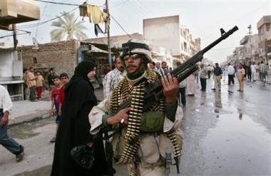 An Iraqi soldier guards the scene of a car bomb explosion Sunday April 16, 2006 in Mahmoudiya, about 30 km (20 miles) south of Baghdad, Iraq. A car bomb exploded in the public market in Mahmoudiya, a short distance from a mosque, killing at least 10 people and wounding 25, police said.