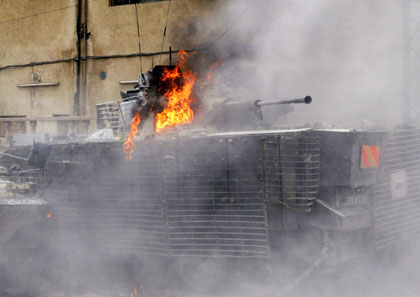 A British armoured vehicle burns after Iraqi and British soldiers clashed with Iraqi residents following a British helicopter crash in Basra, 550 Km, (341miles) south of Baghdad May 6, 2006. A British military helicopter was shot down by a rocket in the southern Iraqi city of Basra on Saturday, Iraqi police said, and firefighters said they had found four charred bodies in the wreckage. 