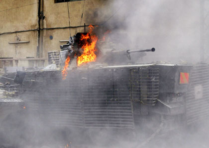 A British armoured vehicle burns after Iraqi and British soldiers clashed with Iraqi residents following a British helicopter crash in Basra, 550 Km, (341miles) south of Baghdad May 6, 2006. A British military helicopter was shot down by a rocket in the southern Iraqi city of Basra on Saturday, Iraqi police said, and firefighters said they had found four charred bodies in the wreckage.