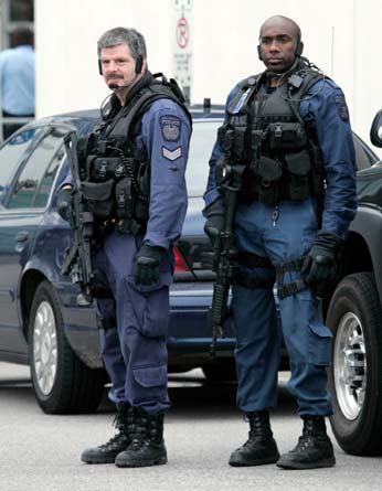 Police officers guard a courthouse in Brampton, Ontario, a suburb of Toronto, June 3, 2006. Seventeen Canadian residents arrested on terrorism charges were inspired by al Qaeda, had amassed enough explosives to build huge bombs and were planning to blow up targets in densely populated Ontario, police said on Saturday.