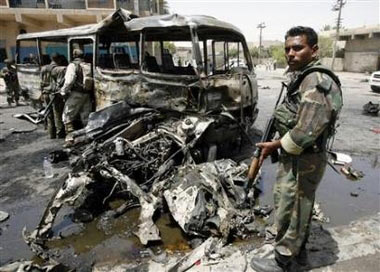 Iraqi soldiers secure the scene of a mini bus bomb attack, which killed four people, and wounded 14 in eastern Baghdad, June 17, 2006. (Ali Jasim/Reuters)