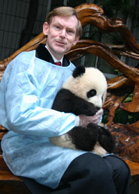 Zoellick holds a panda cub during a visit to a panda preserve in Chengdu, Southwest China's Sichuan Province January 25, 2006. [newsphoto]