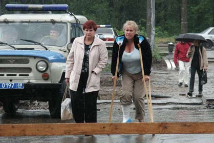  wounded woman who was a passenger of the Airbus A-310 which crashed landed makes her way on crutches to the airport building at Russia's Siberian city of Irkutsk, July 9, 2006.
