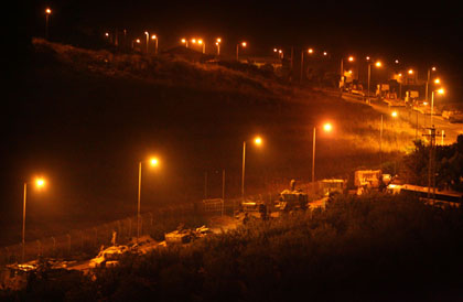 Israeli army vehicles are lined up before going into Lebanon north of Kiryat Shmona, close to the Israel-Lebanon border, early morning July 30, 2006.