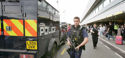 Armed British police officers patrol Terminal Four of Heathrow airport in London August 12, 2006. The British government on Saturday rejected as "dangerous and foolish" accusations that its foreign policy heightened the threat of terror attacks after police foiled a plot to blow up transatlantic airliners.