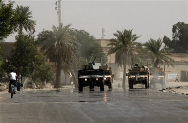 US troops patrol a deserted Baghdad street Saturday Sept. 30, 2006 as the Iraqi government ordered a complete ban in Baghdad to pedestrian and vehicular traffic through Sunday morning. The curfew was put into place on the advice of U.S. forces following the arrest of a bodyguard, detained at the home of a leading Sunni Arab politician and suspected of being a member of al-Qaida in Iraq. (AP