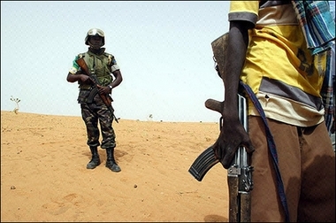 An African Union soldier stands guard as a rebel from the Sudan Liberation Army talks with members of an AU patrol outside the village of Fakili in Darfur, June 2006. The United States is showing frustration over the United Nations' inability to force Sudan's government to accept UN peacekeepers for strife-torn Darfur.(AFP