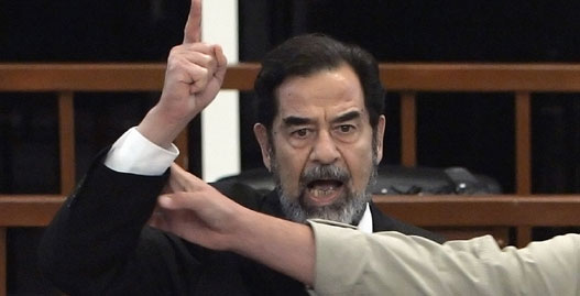 Former Iraqi President Saddam Hussein yells in court as he receives his verdict, as a bailiff attempts to silence him, during his trial held under tight security in Baghdad's heavily fortified Green Zone November 5, 2006. A visibly shaken Saddam Hussein was found guilty of crimes against humanity and sentenced to hang on Sunday at a lightning session of the U.S.-backed court trying him in Baghdad.