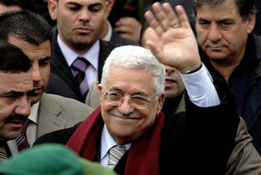 Palestinian President Mahmoud Abbas, also known as Abu Mazen, waves to Palestinian students demonstrating as he leaves after opening an exhibition in the West Bank town of Ramallah, Monday, Nov. 6, 2006. Abbas and negotiators from the Islamic militant Hamas have reached agreement in principle on forming a government of technocrats, but still need to wrap up important details, a Hamas Cabinet minister said Monday.(AP