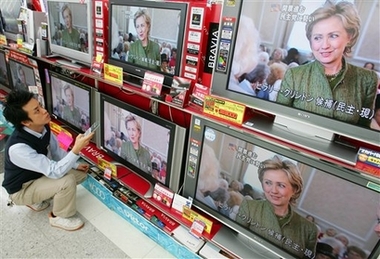 Sales person Tomoaki Soma adjusts TV screens as an interview of re-elected Sen. Hillary Rodham Clinton is aired at Tokyo's Kimuraya Select electric/electronics discount store in Tokyo Wednesday, Nov. 8, 2006. Clinton coasted to a second Democratic term in New York, winning roughly 70 percent of the vote in a warm-up to a possible run for the White House in 2008. (AP 